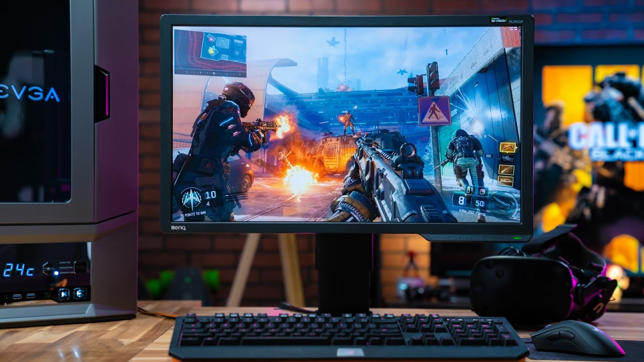 Close-up on a PC monitor against a brick background, where a non-descript First person shooter game is rendered on-screen.