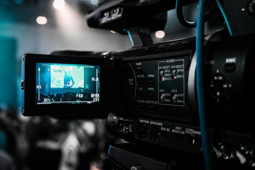 Close up photo of a video production camera with the view screen open.